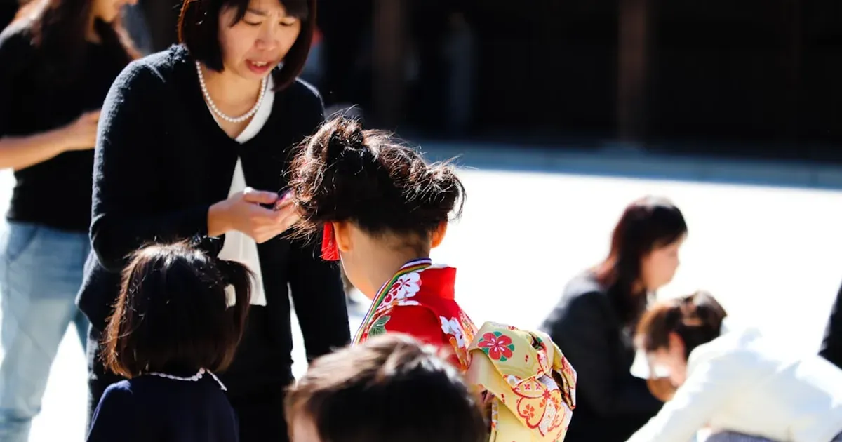 A family with two children exploring a Tokyo street in bright sunlight