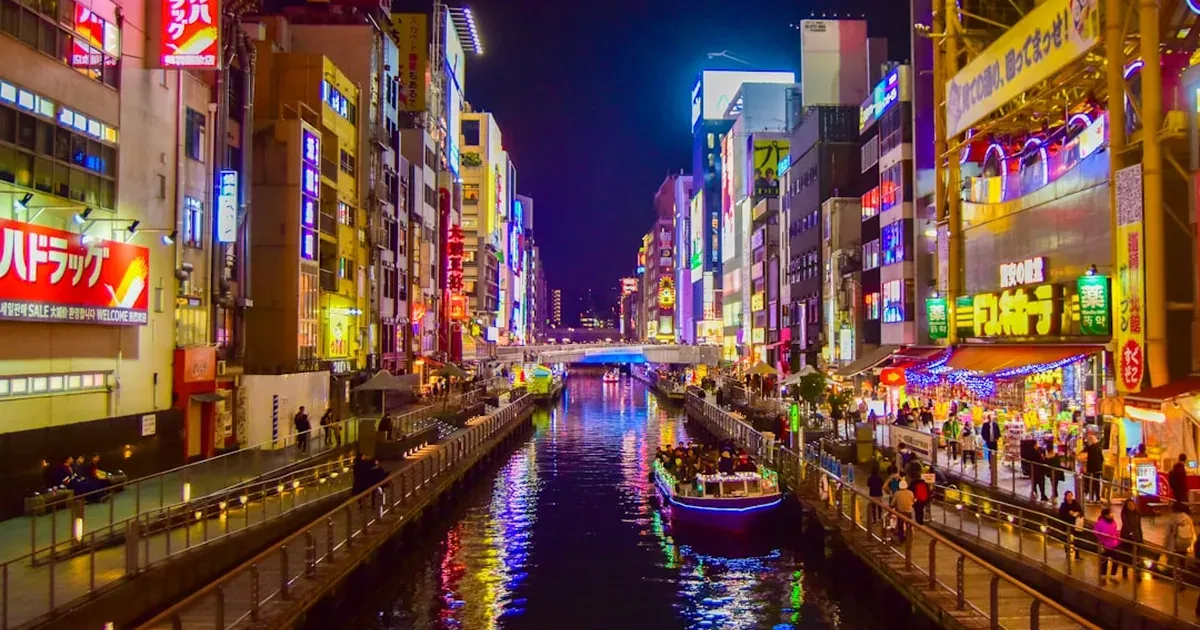 Dotonbori canal in Osaka at night with neon signs reflecting on the water and the Glico Running Man advertisement