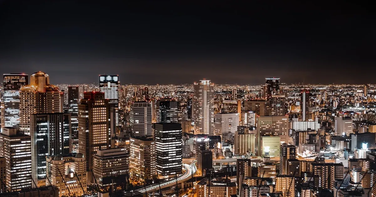 Osaka city skyline at dusk with modern skyscrapers reflected in the river below