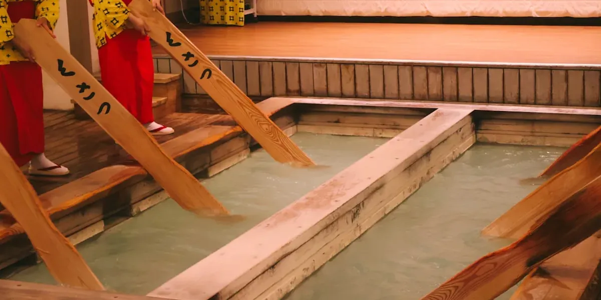 Interior of a Japanese sento public bath with tiled walls and steam