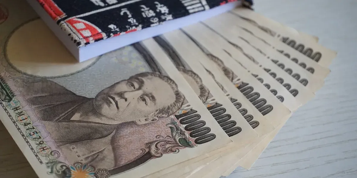 Japanese yen banknotes and coins spread out for travel budget planning