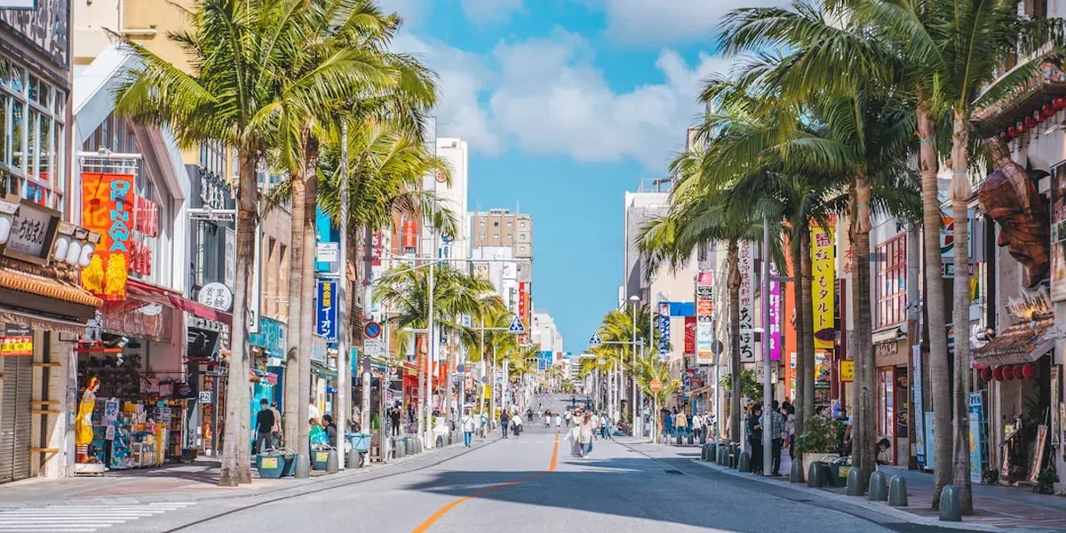 Kokusai-dori main street in Naha Okinawa with shops, restaurants, and crowds of tourists under tropical sun