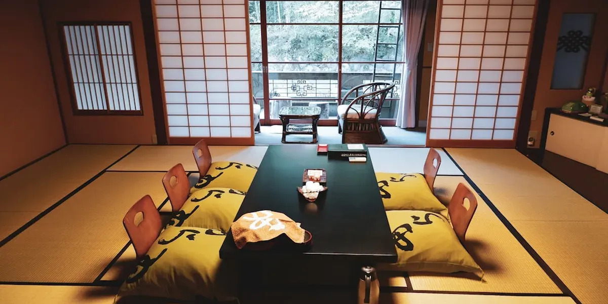 Traditional Japanese guesthouse tatami room with futon bedding and shoji screen windows