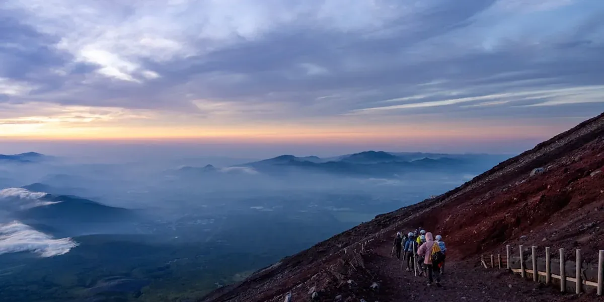 Hikers climbing the trail on Mount Fuji Japan with other climbers visible below