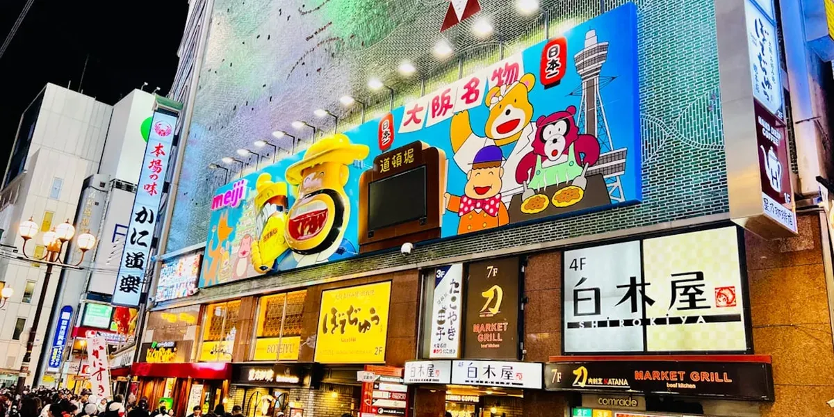 Osaka Dotonbori canal at night with neon lights and crowds