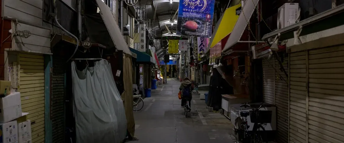 Long covered shopping arcade in Japan with small independent local shops stretching into distance