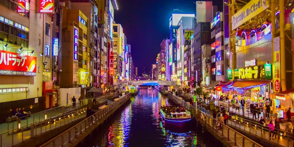 Dotonbori canal in Osaka at night with neon lights reflecting brilliantly on the water