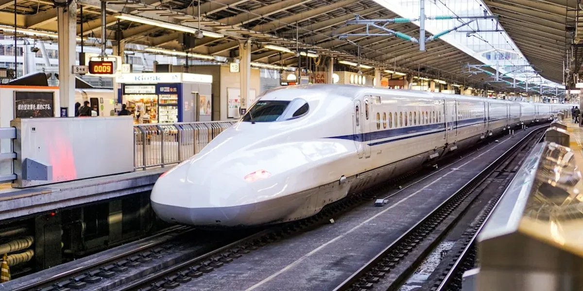 White Shinkansen bullet train stopped at a Japanese station platform