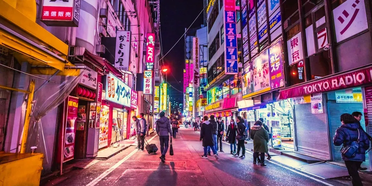 A Tokyo street at night with neon signs, illustrating the safe urban environment