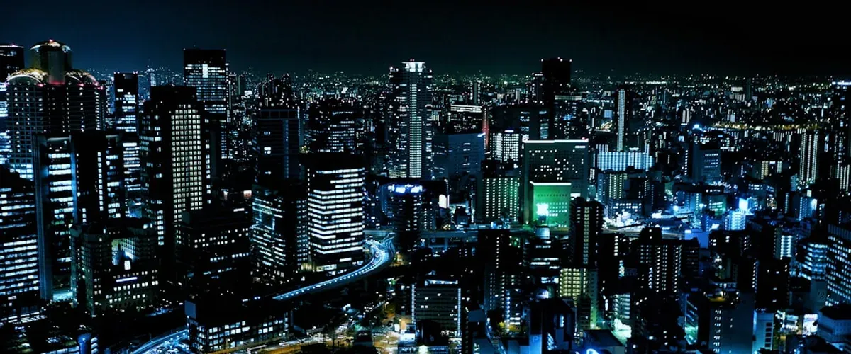 The Umeda Sky Building in Osaka at night with its distinctive twin-tower connected roof architecture
