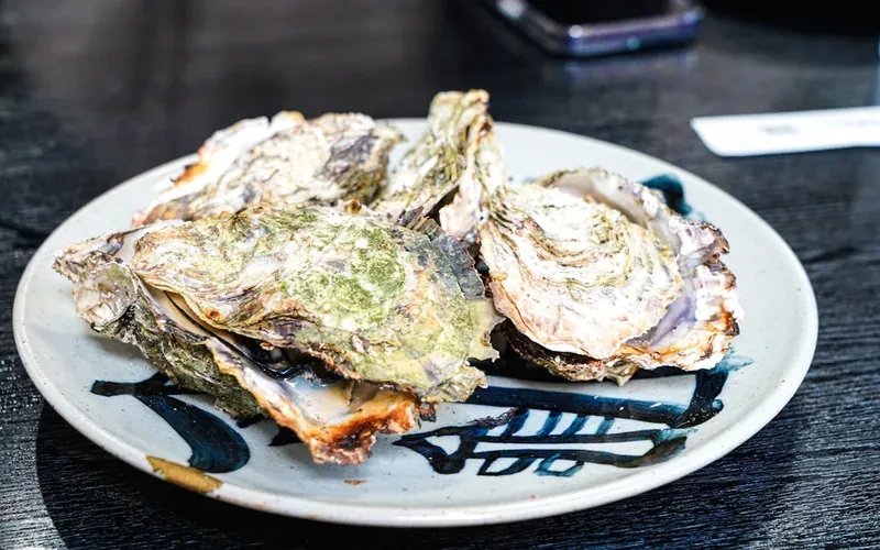 Freshly grilled oysters on charcoal at a Miyajima Island food stall