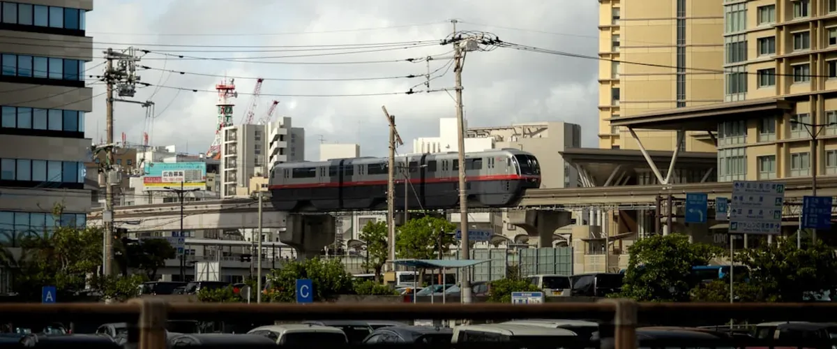 The Yui Rail monorail running through Naha Okinawa with tropical vegetation and low-rise buildings in the background