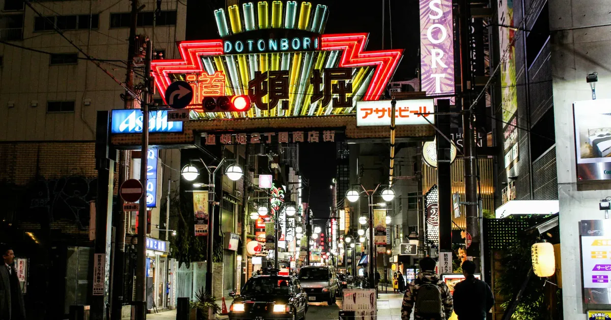 Dotonbori canal at night in Osaka Japan with neon lights and street food stalls